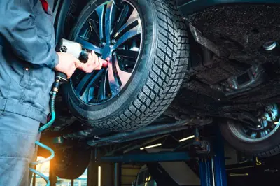 Montage d’un pneu pour une voiture électrique par un garagiste sur un véhicule électrique