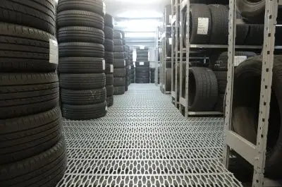 Stock de pneus pour voitures électriques entreposés dans un garage