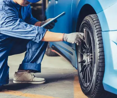 Garagiste qui contrôle pneu