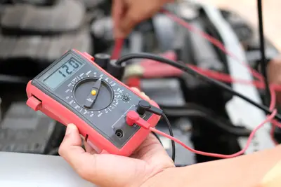 Test d'une batterie de voiture auto avec multimètre