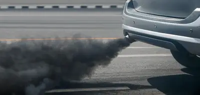 Voiture qui fume noir épaisse fumée noire sortant du pot d’échappement