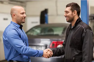 automobiliste et garagiste souriants